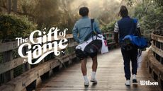 Two golf players carry golf bags and clubs