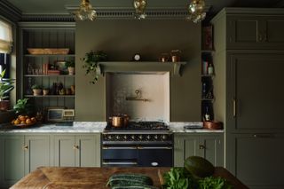 A traditional green kitchen with brass and copper details