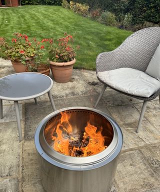 Solo Stove 2.0 Bonfire Fire Pit alight on stone patio