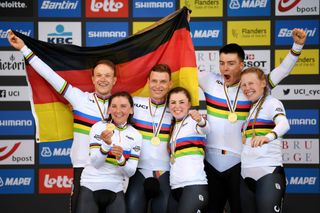 BRUGES BELGIUM SEPTEMBER 22 LR Gold medalists Nikias Arndt of Germany Lisa Brennauer of Germany Tony Martin of Germany Lisa Klein of Germany Max Walscheid of Germany and Mieke Kroger of Germany with world champion jerseys celebrate on the podium while holding the flag of they country during the medal ceremony after the 94th UCI Road World Championships 2021 Team Time Trial Mixed Relay a 445km race from KnokkeHeist to Bruges the day cyclist Tony Martin of Germany withdraws from professional cycling flanders2021 TT on September 22 2021 in Bruges Belgium Photo by Tim de WaeleGetty Images