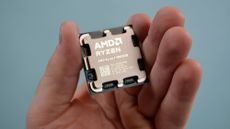 An AMD Ryzen 7 9800X3D in a masculine hand