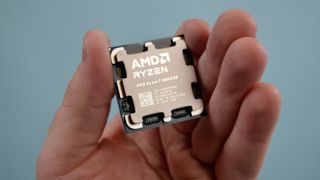 An AMD Ryzen 7 9800X3D in a masculine hand