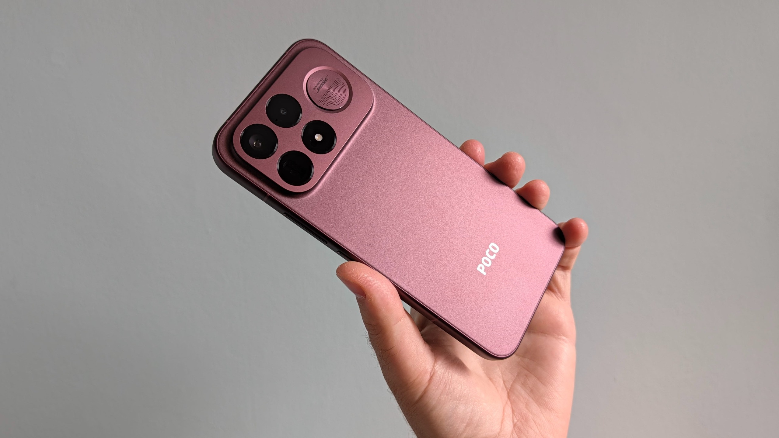 The Poco F9 Ultra being held in the hand and resting on a table