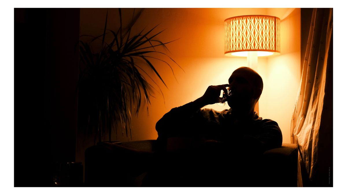 A man silhouetted against an orange light