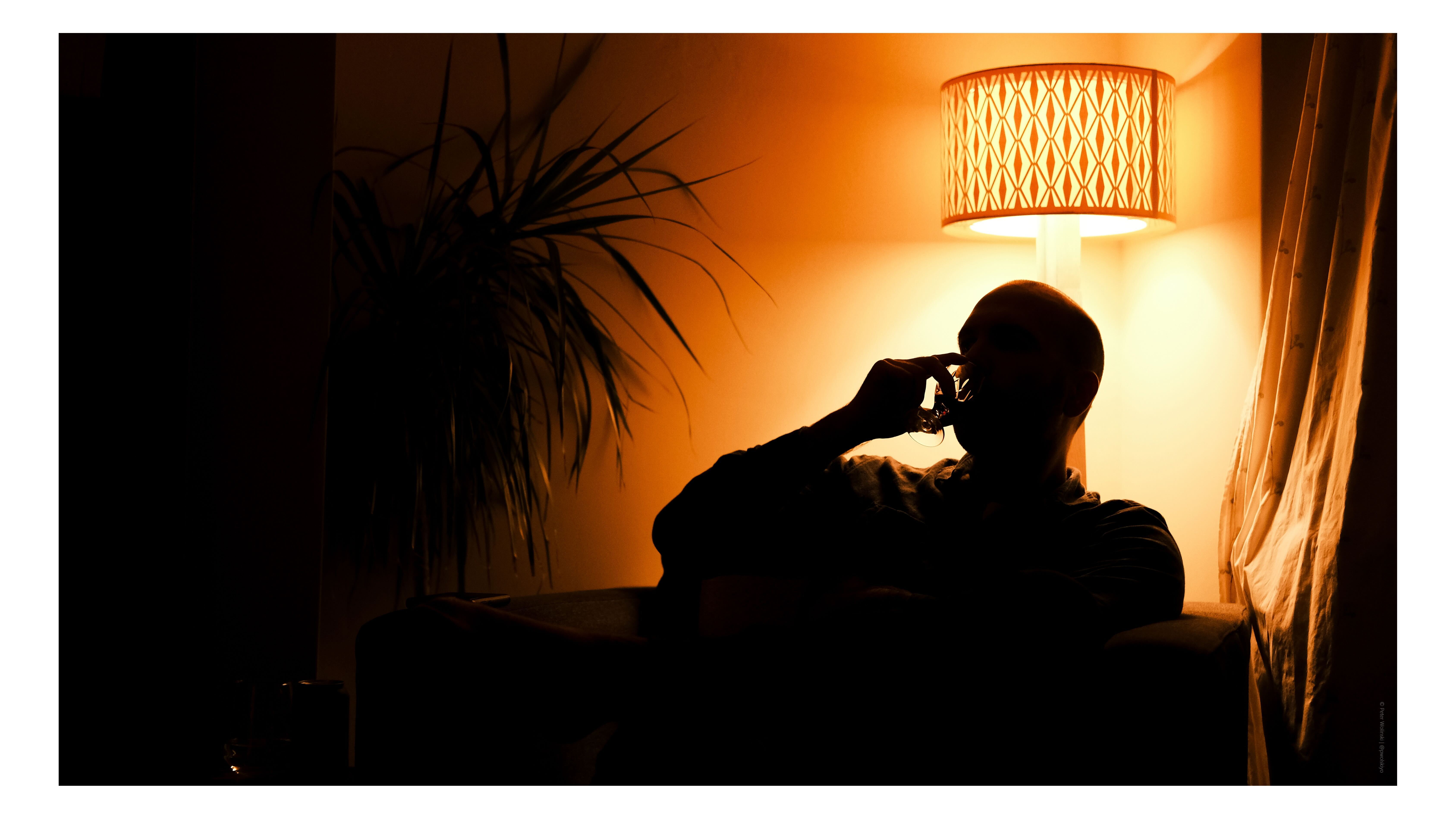 A man silhouetted against an orange light 