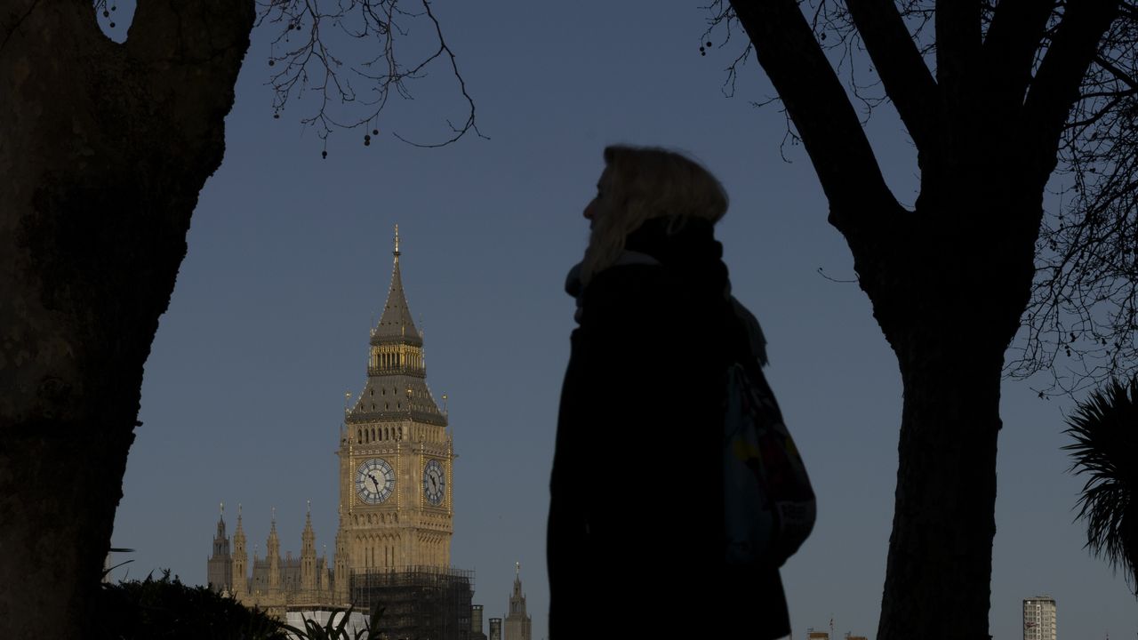 A woman silhouetted against the Palace of Westminster 