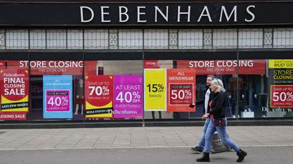 Signs in the window of a closing Debenhams store offer sales bargains on the High Street in Winchester, south west England on March 31, 2021. 