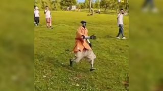 A still from a Douyin video showing a robot running down a hill wearing a peach-coloured shirt and shorts