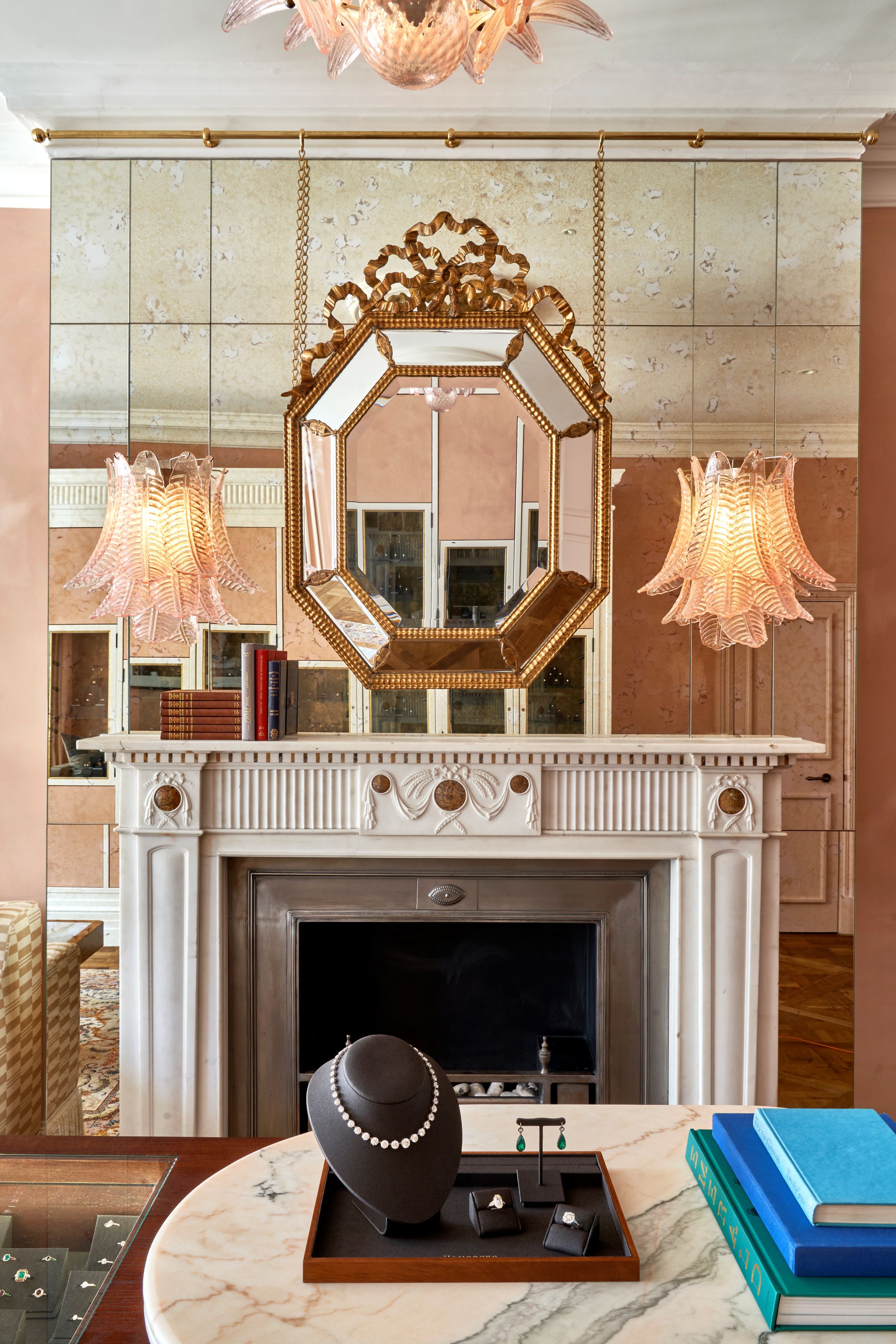 jewellery showroom with a fireplace on an antiqued mirror wall with two murano glass sconces either side