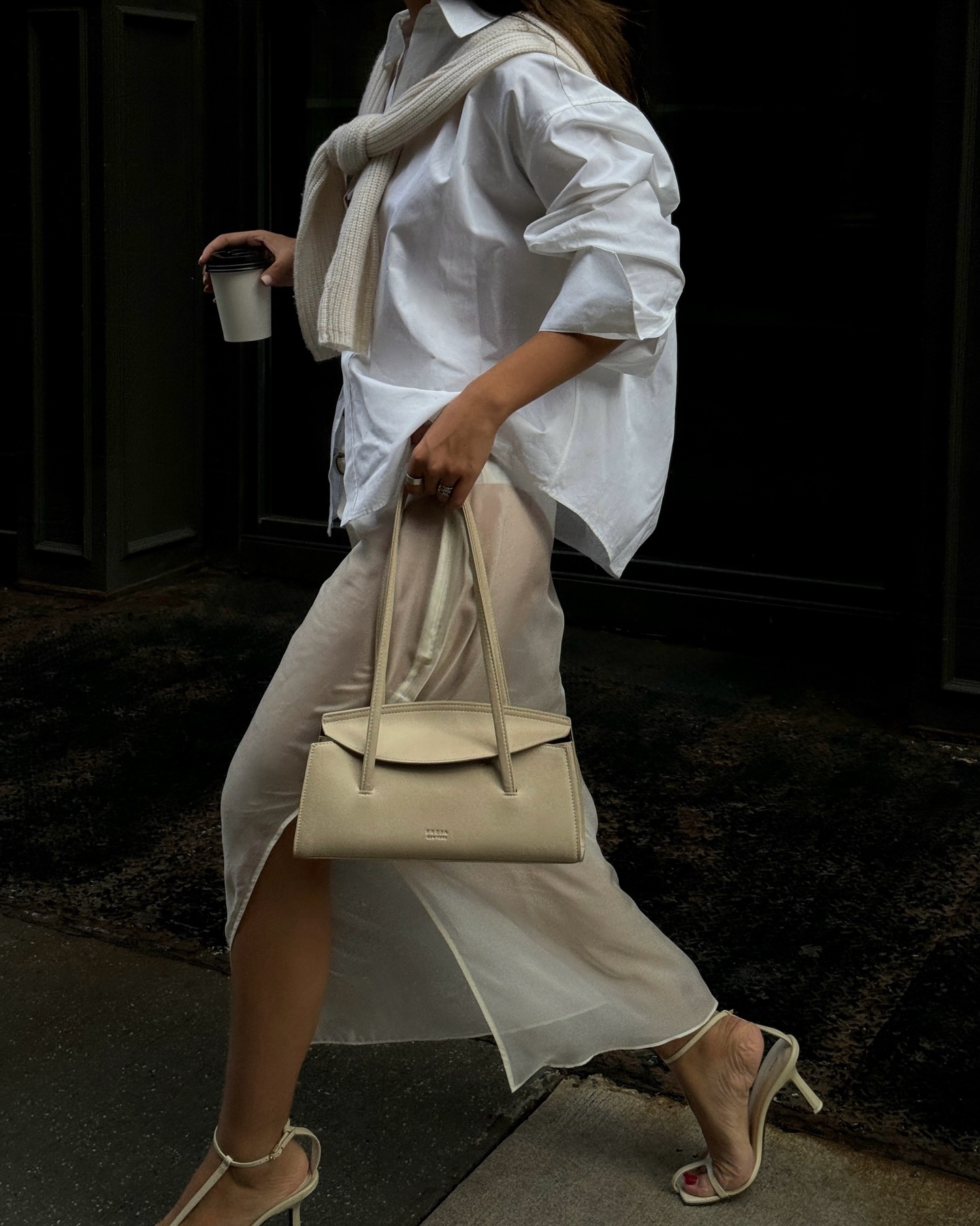 @thecarolinelin wears a sheer skirt and a white cotton shirt with heels