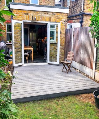 Grey composite decking in the back garden of a house