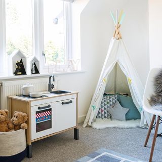 playroom with white wall and white tent with cabinet and carpet flooring