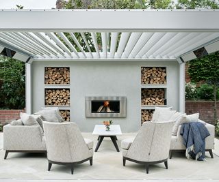 outdoor room set up with furniture, fire place and log storage