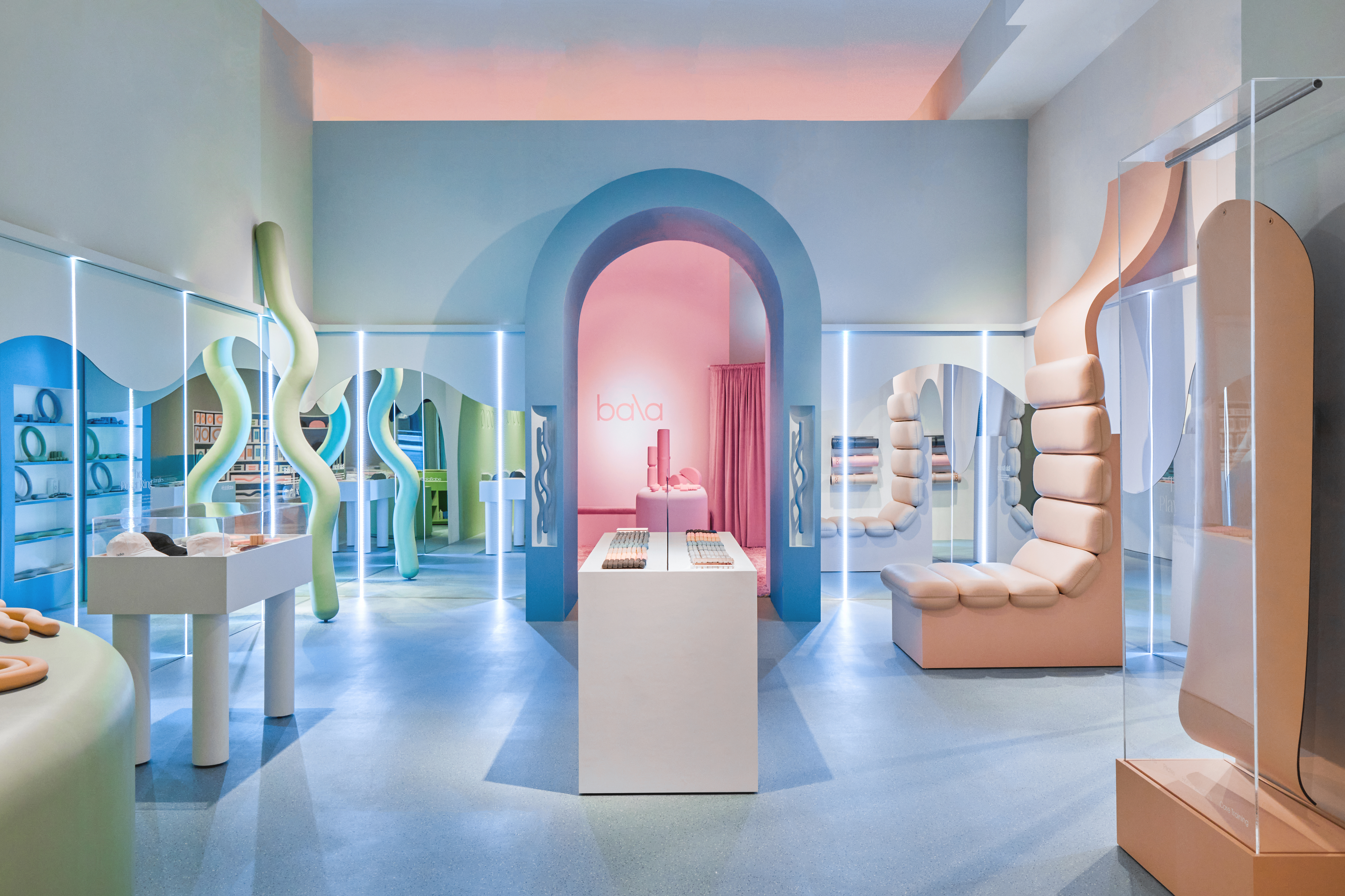 A pastel-hued fitness store features whimsical lines and blown-up sculptures inspired by the brand's sport accessories and weights.