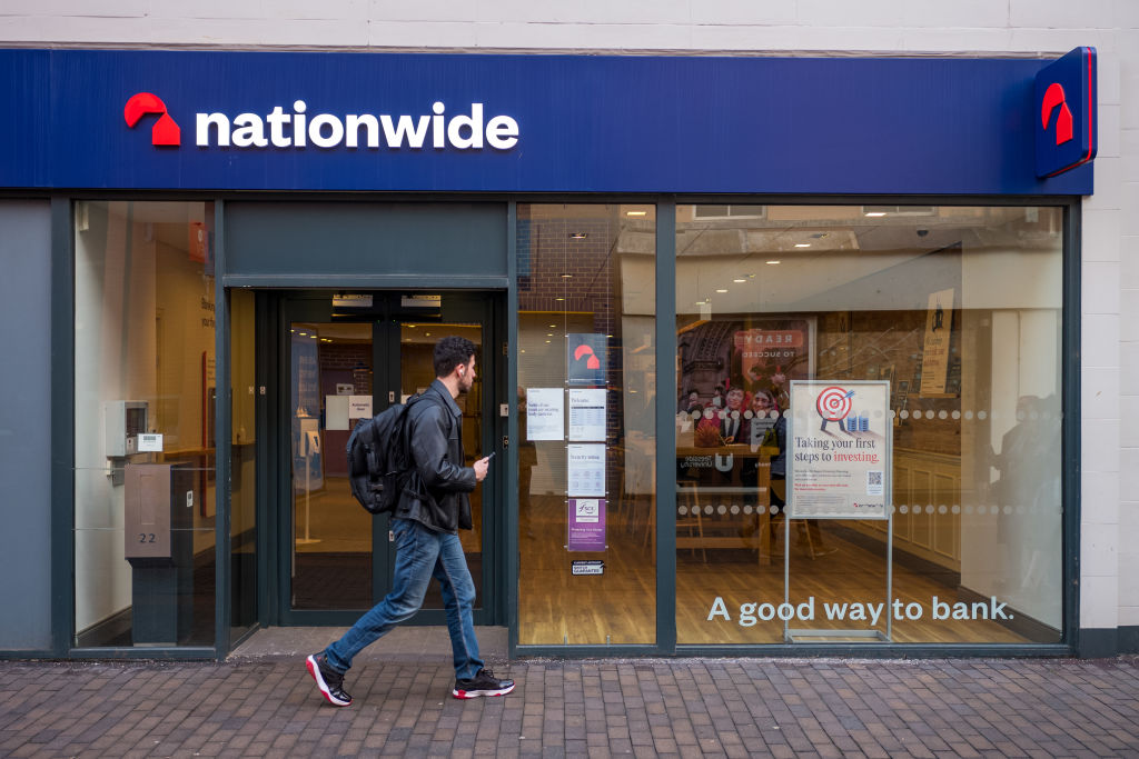 Man walking past branch of Nationwide