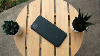 Google Pixel 5a med framsidan nedåt på ett bord.