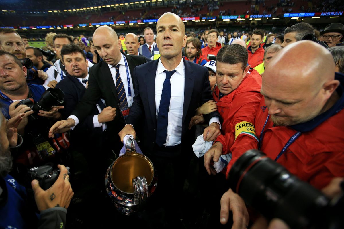 Real Madrid manager Zinedine Zidane carries the Champions League trophy after his side's victory over Juventus in the 2017 final in Cardiff