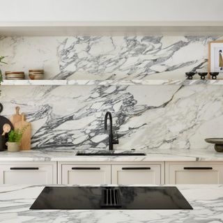 Kitchen with marble backsplash and worktop, modern fixtures and open shelving