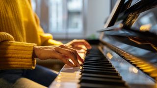 Close-up of a woman's hands as she plays the piano