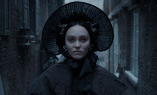 lily rose depp as ellen hutter in a big bonnet walking down an alley in robert eggers' nosferatu