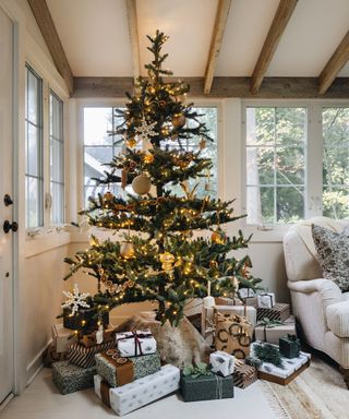 Christmas tree and gifts decorated in a Scandi woodland theme in a neutral living room with ceiling beams