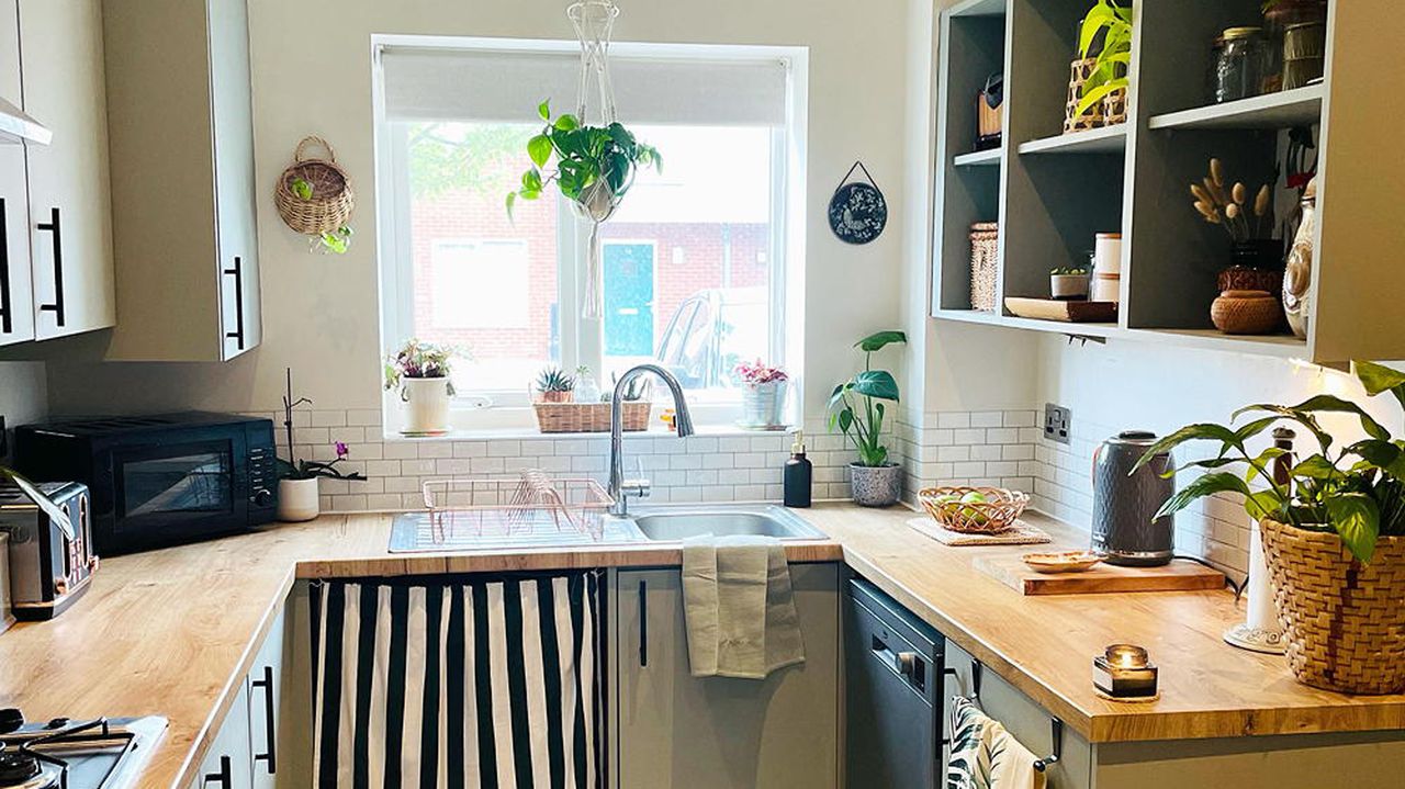 Green kitchen with black and white striped curtain