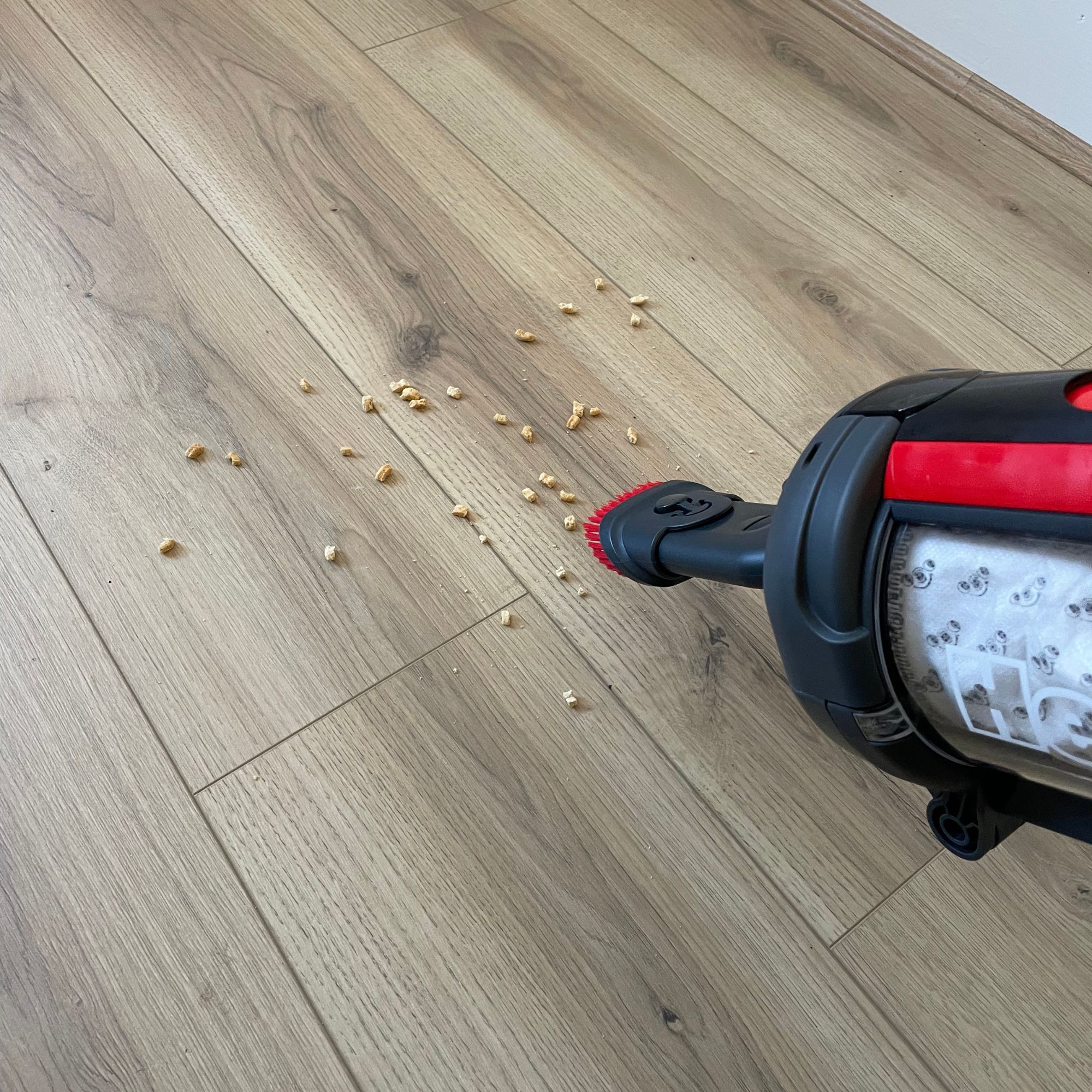 Henry Quick Corded Vacuum Cleaner picking up crushed cereal with a tool