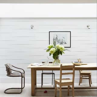 kitchen with white wall with table and chairs