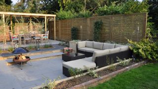 contemporary garden with slatted fence and fire pit