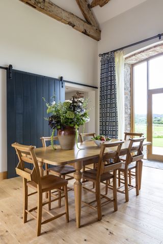 dining room in full height space with beams inrestored Welsh barn