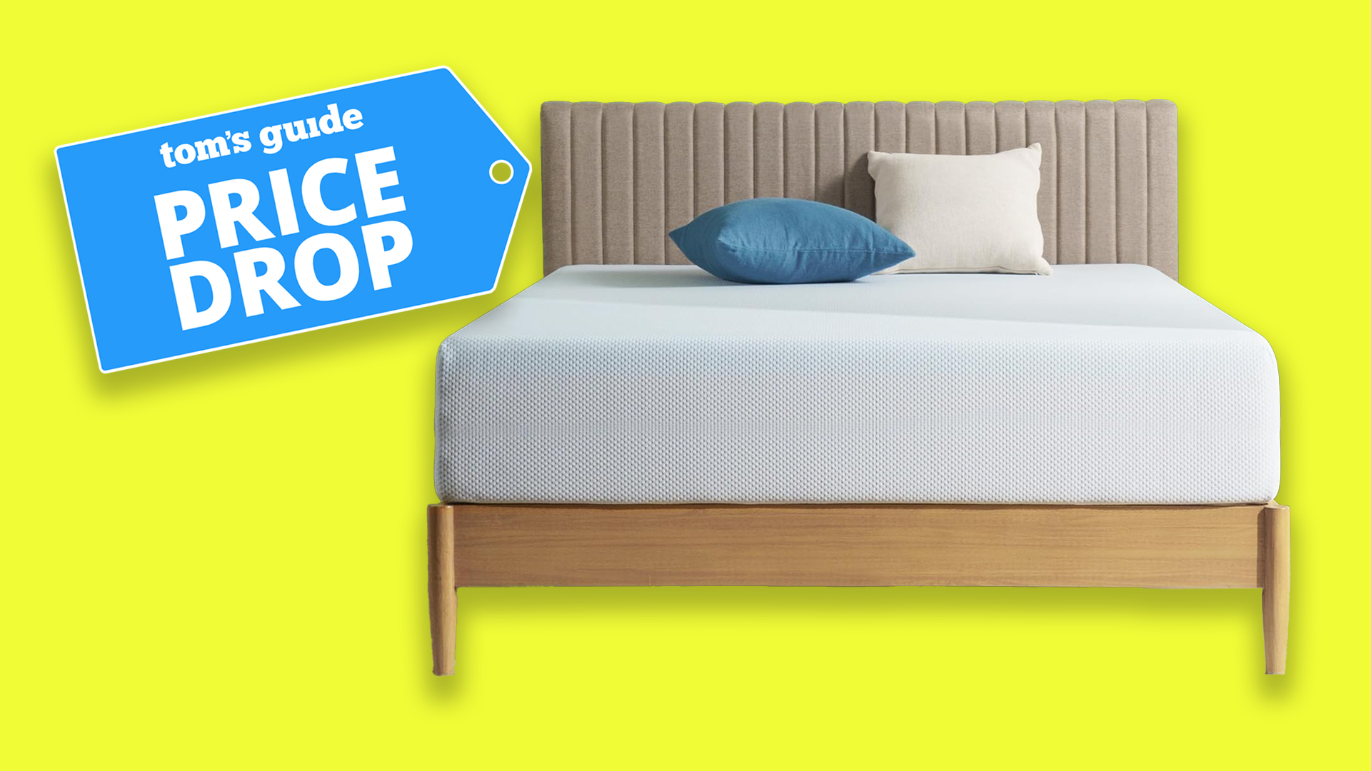 A Zinus Green Tea Memory Foam Mattress on a bed frame with two cushions at the head of the bed, against a yellow background. To the left, a Tom&#039;s Guide price drop deals graphic