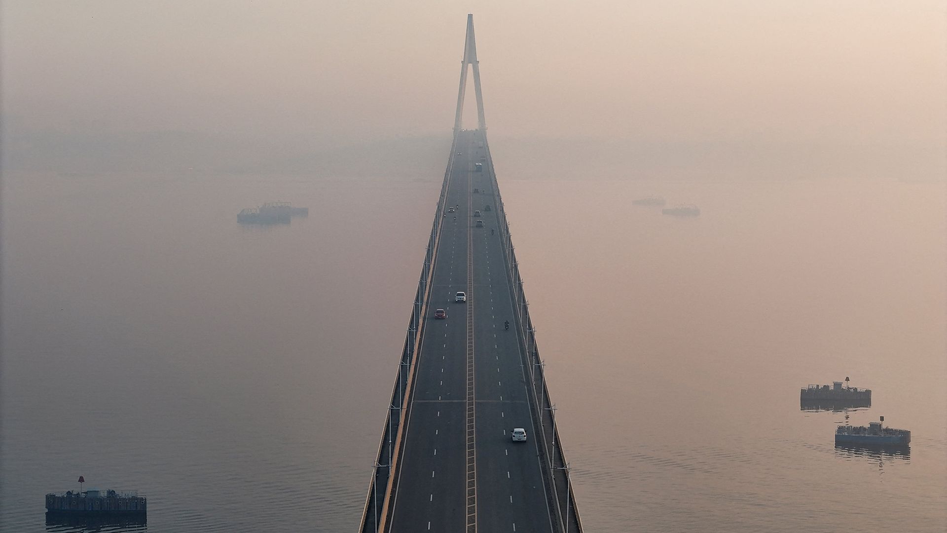 Smoke from Amazonian wildfires and a burning landfill shrouds the Rio Negro bridge in Manaus, Brazil