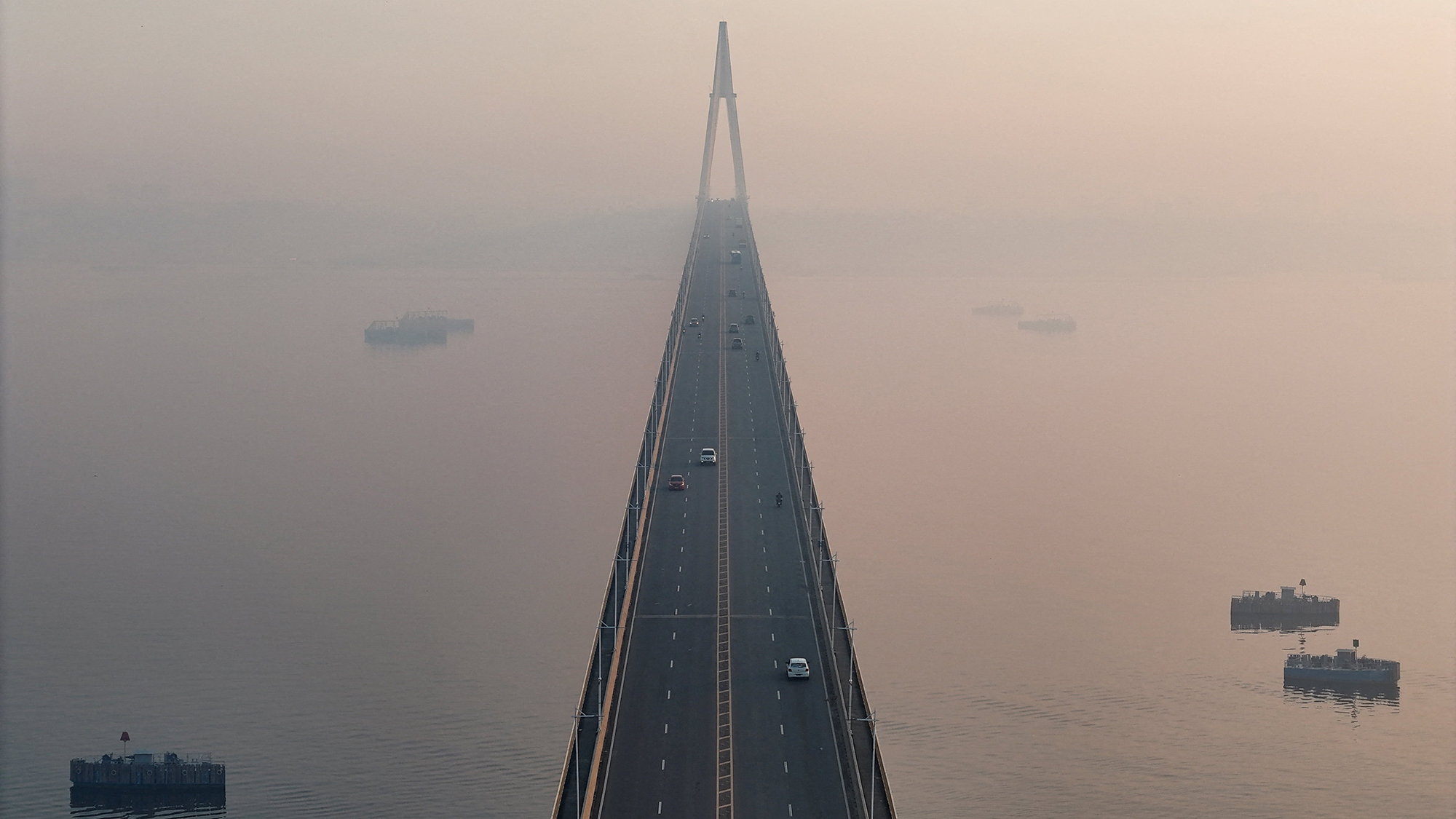 Smoke from Amazonian wildfires and a burning landfill shrouds the Rio Negro bridge in Manaus, Brazil