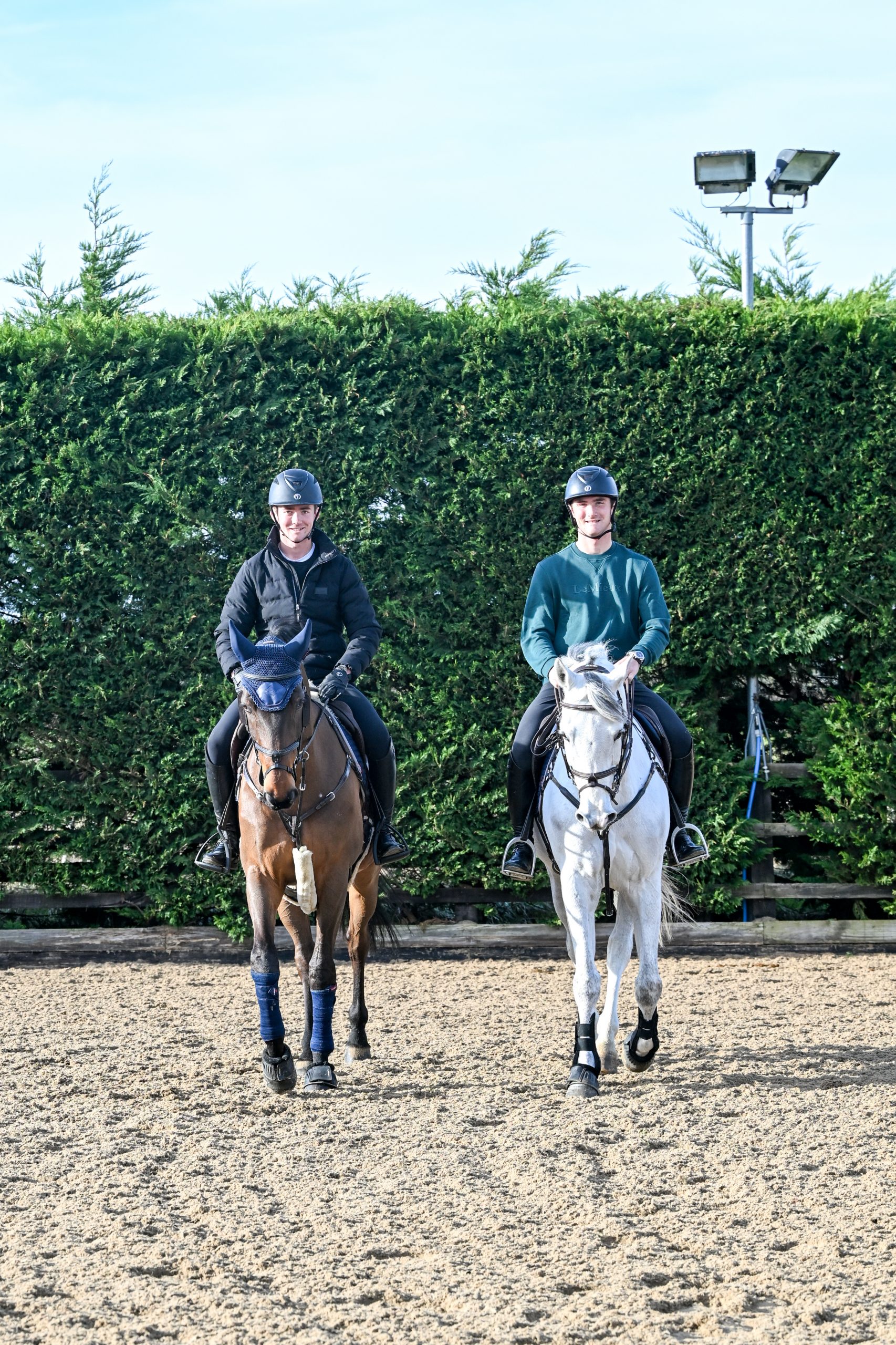 Olli and Will Fletcher riding their horses in the arena