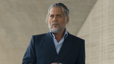 Johnny Depp's mysterious character wearing light blue shirt under a blue blazer, with long gray hair tied back, and a gray beard and mustache in Day Drinker