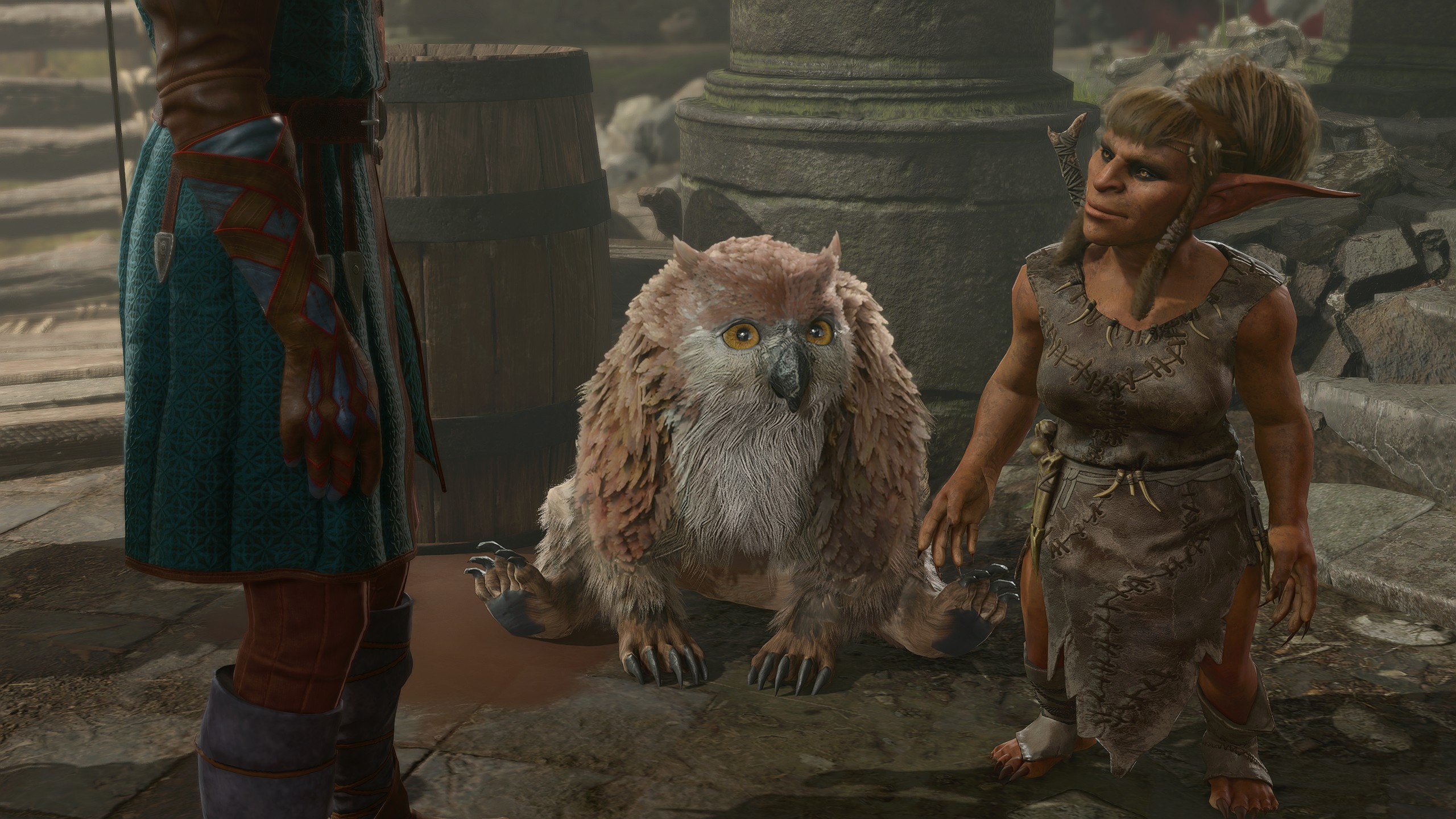 An owlbear cub squats next to a goblin
