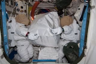 Two unoccupied NASA spacesuits appear to carry a storage bag on the International Space Station in this photo by an Expedition 40 crewmember released on Aug. 8, 2014.
