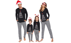 A family in matching black and white pjs pose.