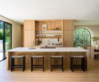 pale wood kitchen with island and four stools