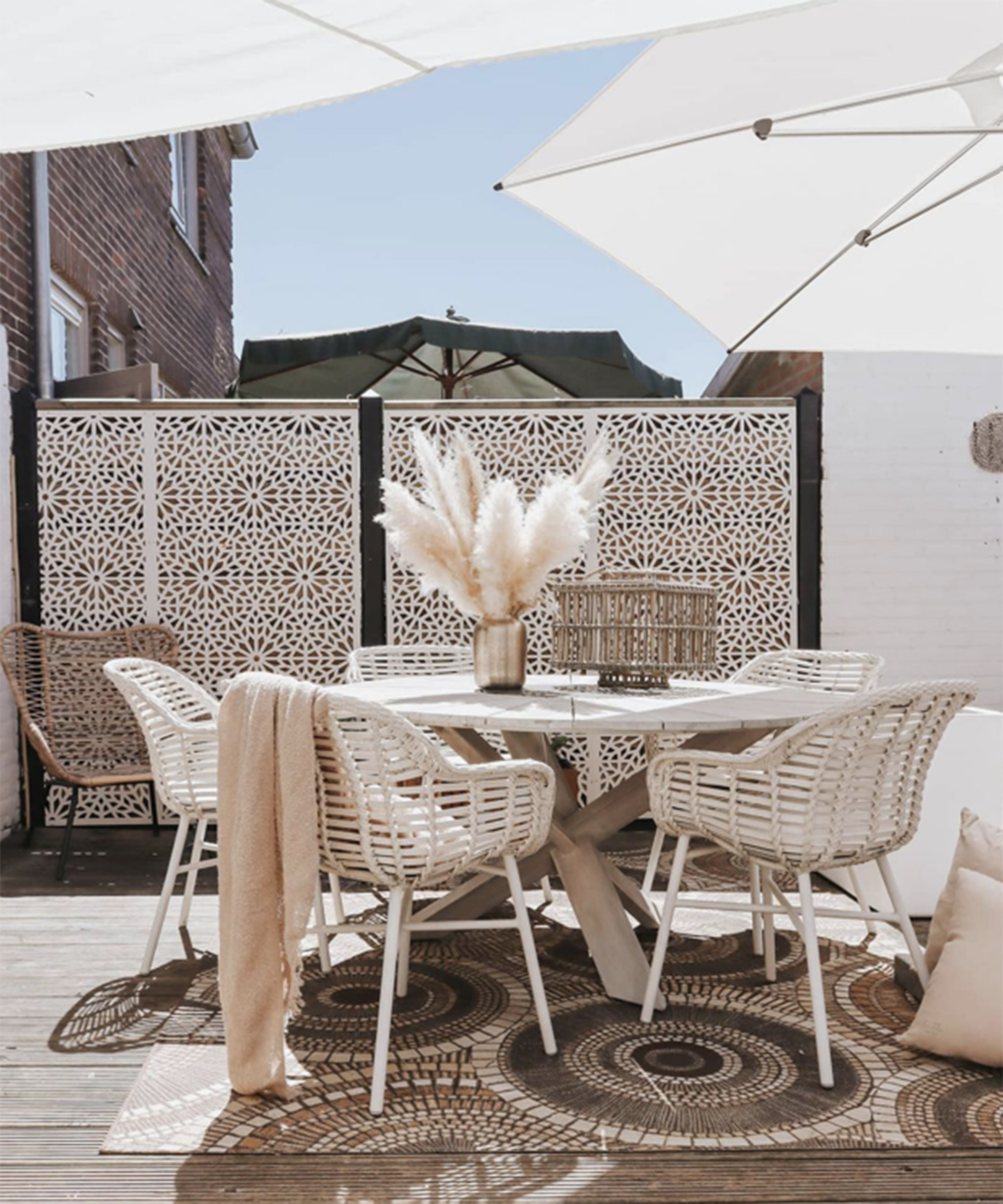 A decking idea with decorative garden privacy screens by Screen with Envy and beige garden furniture with Pampas grass centerpiece