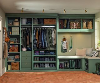 boot room area with green furniture and doors open to show racks of shelving with coats, shoes and boots