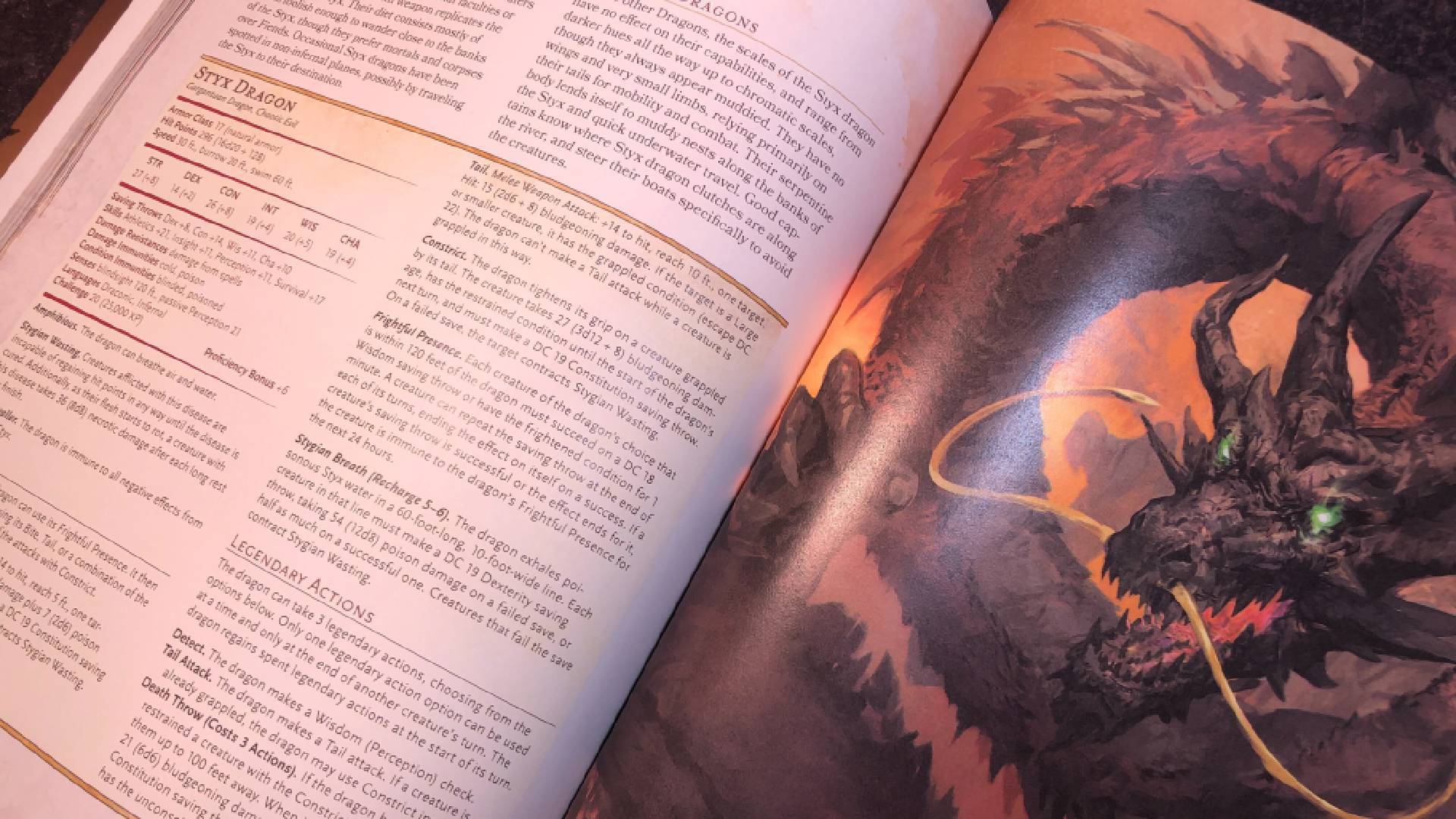 Open pages from Chains of Asmodeus, including an illustration of a dragon
