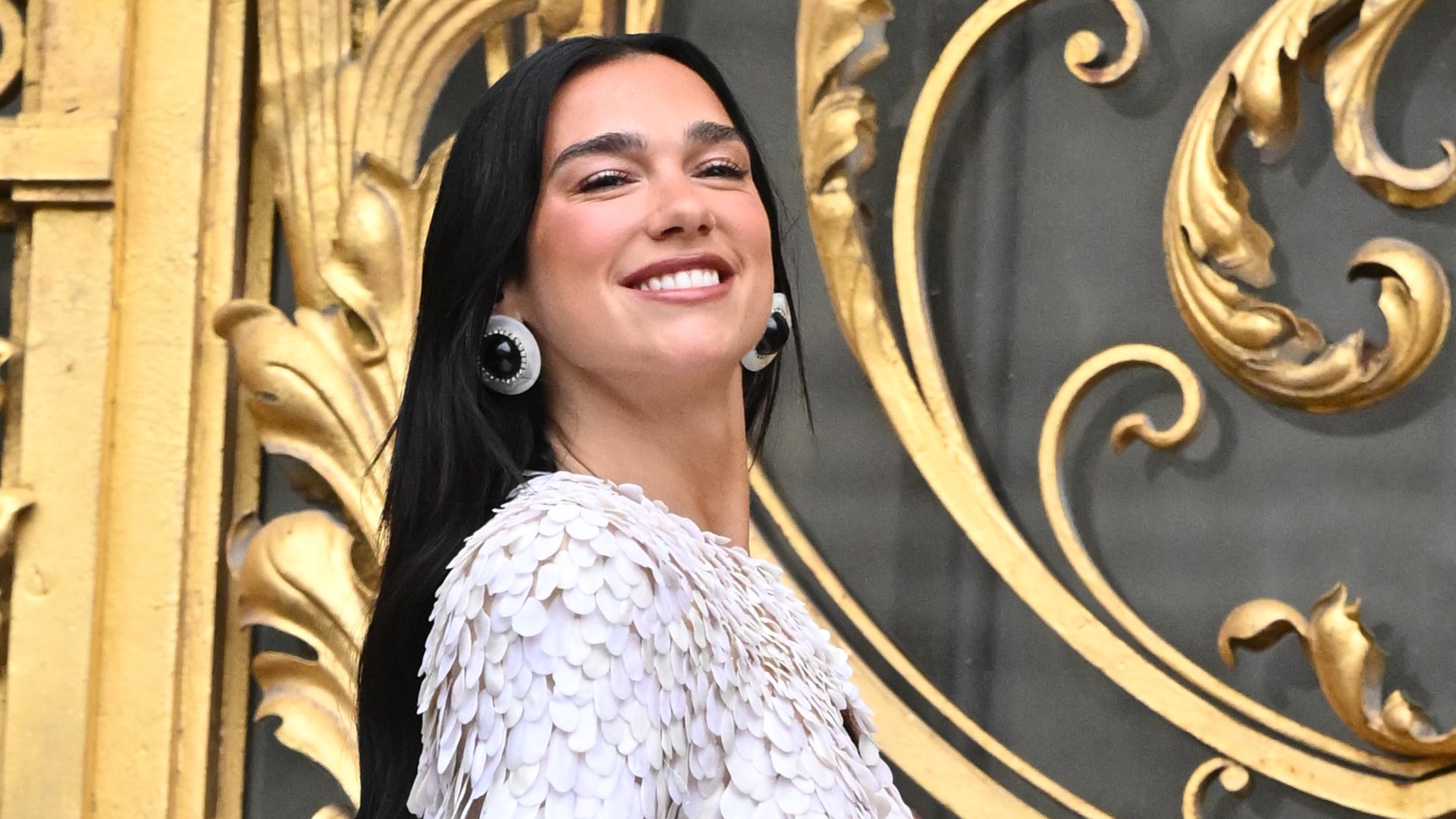 a woman with long black hair in a textured jacket