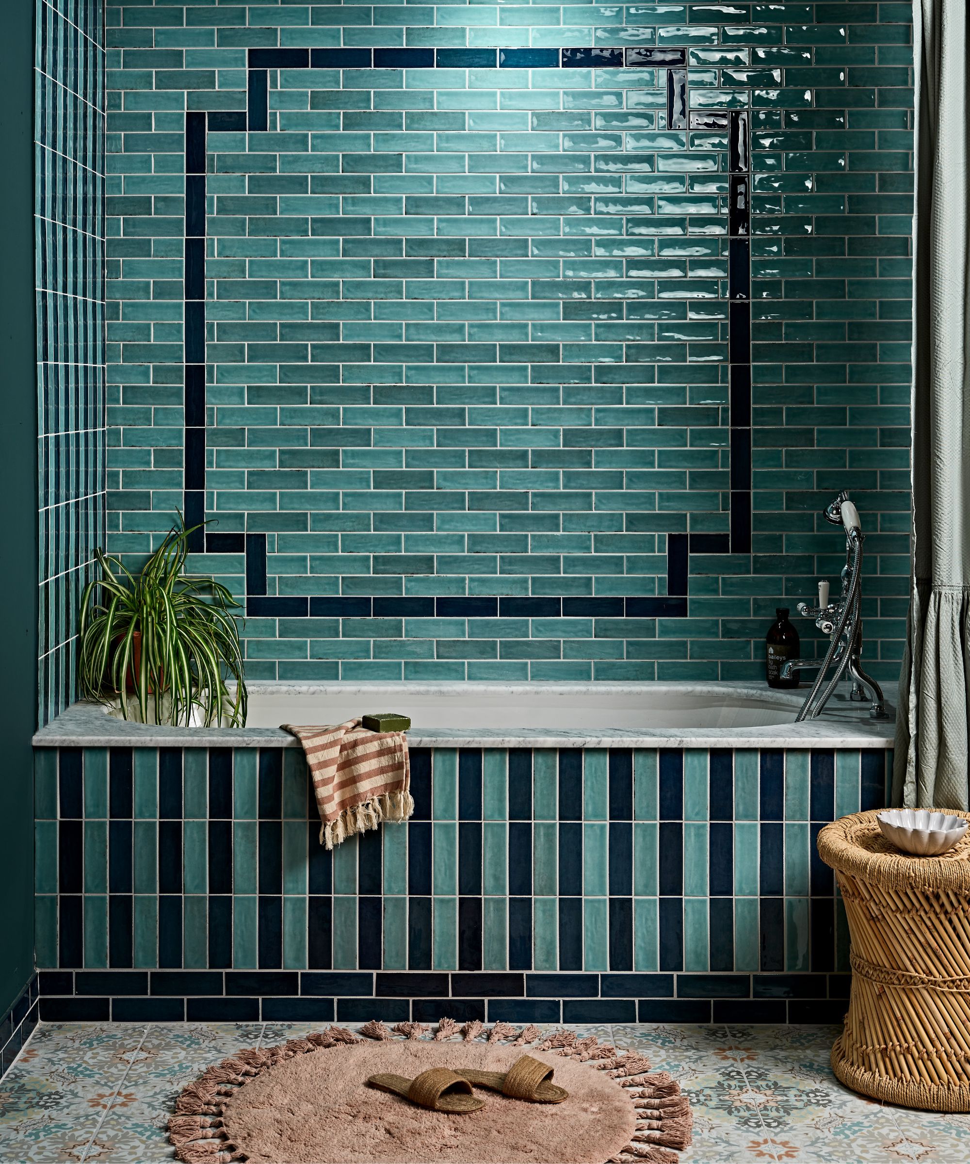 green tiled bath with a striped bath panel