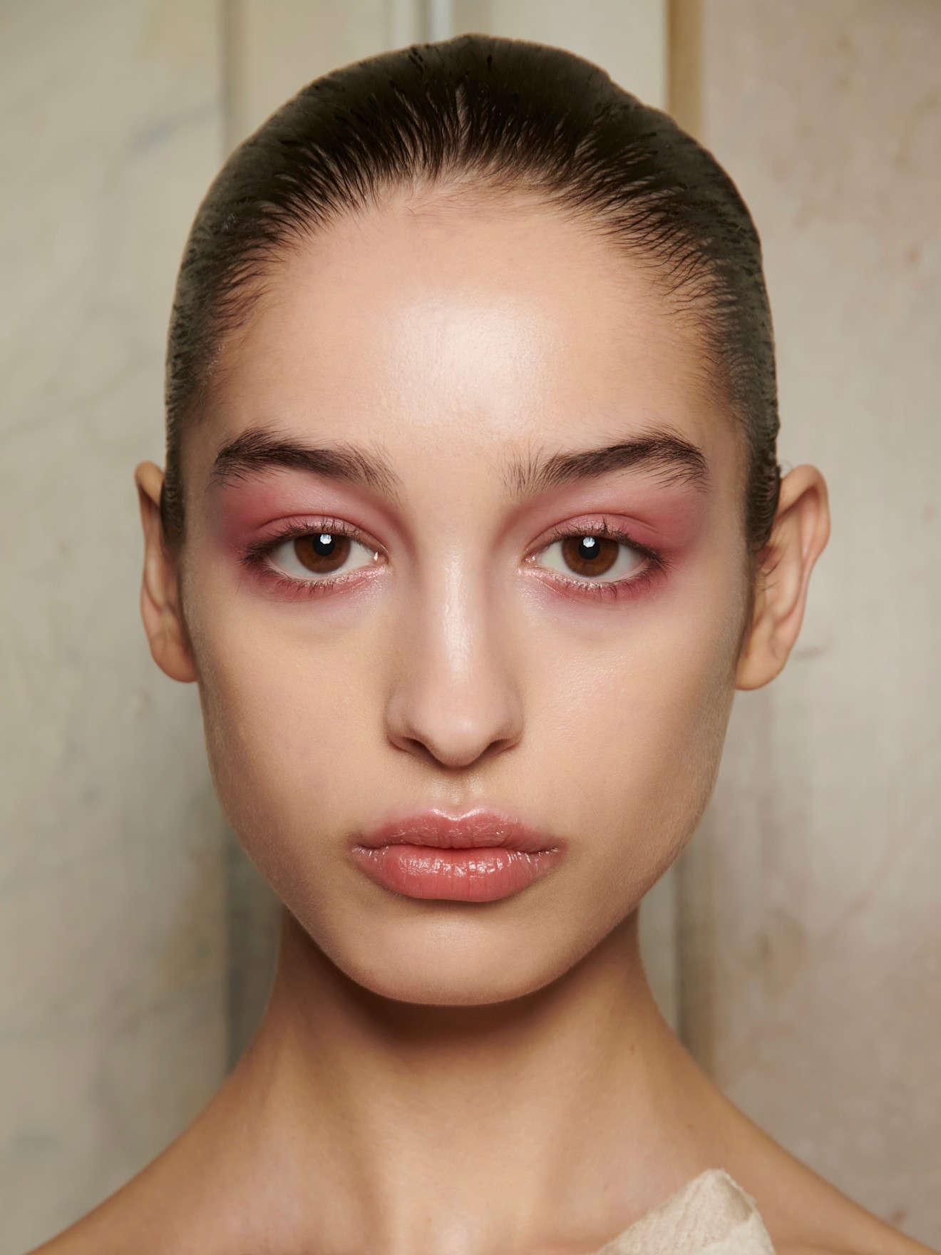 A model wearing a New Years Eve-ready makeup look with rose dusted eyeshadow and a light lipstick