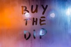 The phrase "buy the dip," one of many investing strategies, written on a steamy window.