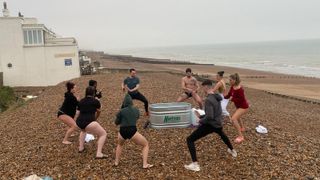 Group of journalists doing the horse stance pose around a Wim Hof tub in Brighton