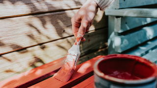 Hand painting wood in orangey red outside