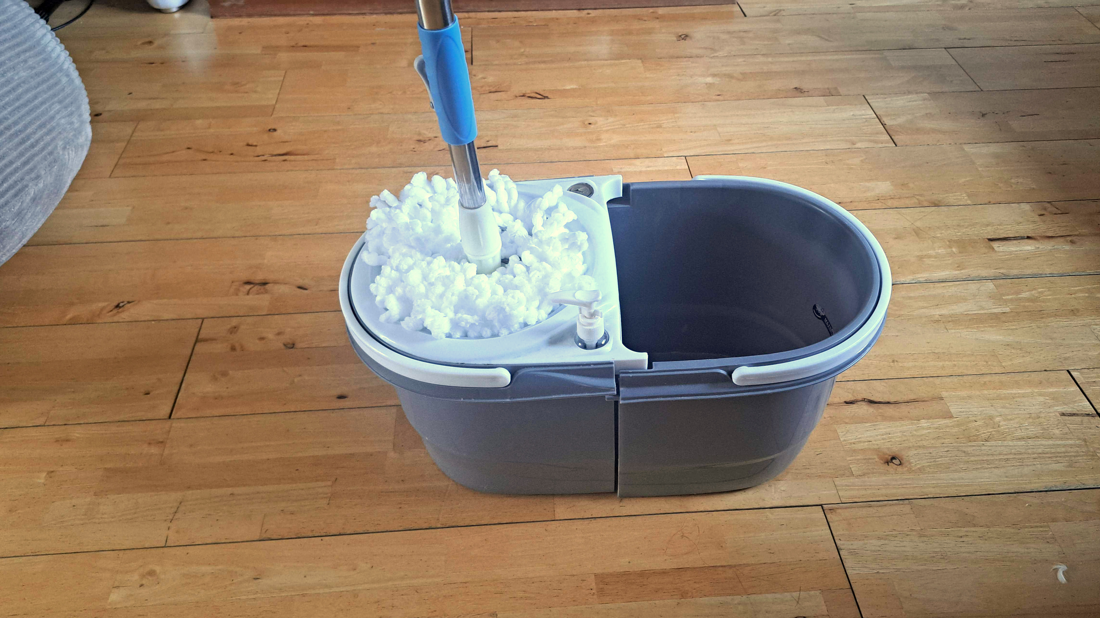 Spin mop and dual bucket on wooden floor