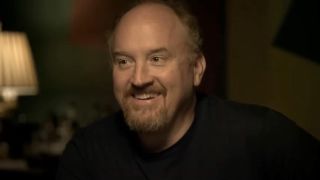 Louis C.K. smiling at table with other comedians in Louie